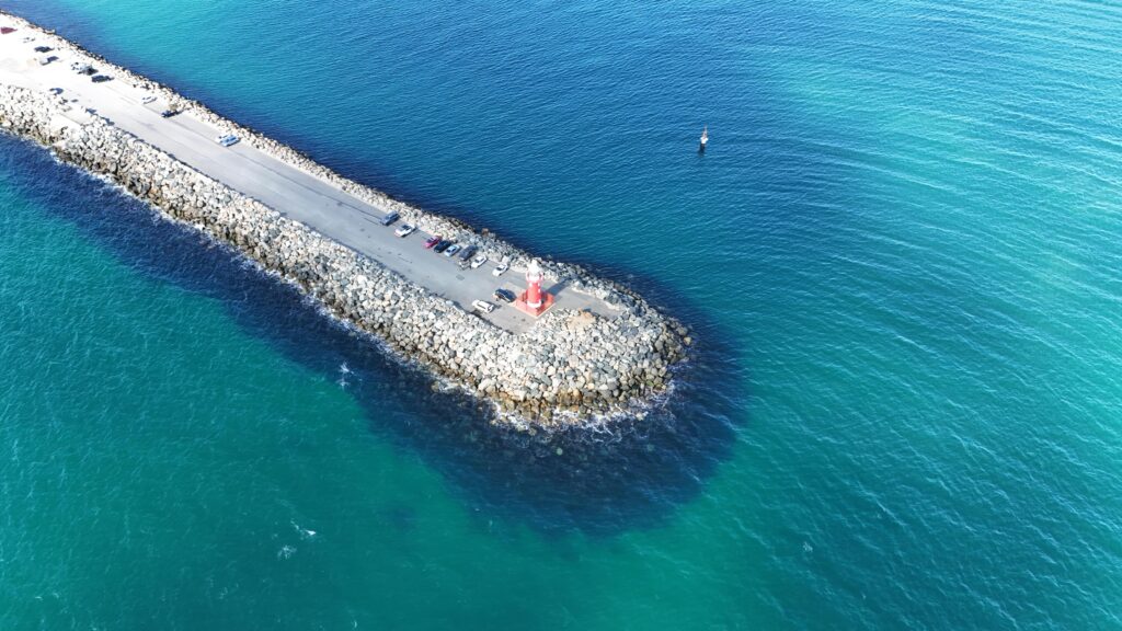 A stunning aerial view of Fremantle's Bather Beach jetty with clear blue waters surrounding it.